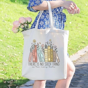 Canvas tote bag with floral books print and inspirational slogan in outdoor setting