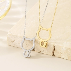 Detailed view of silver and gold minimalist hollow cat pendant necklaces on stone