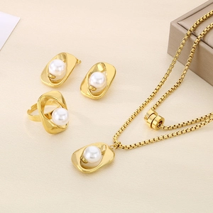 Macro shot of elegant gold pearl jewelry set including necklace, earrings, and ring