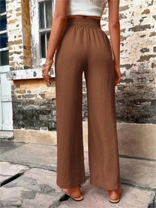 Détail du pantalon marron à taille haute élastique avec une texture en tissu crépon