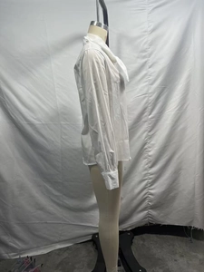 Side view of white long-sleeved shirt with lace trim and elegant pearl buttons on mannequin