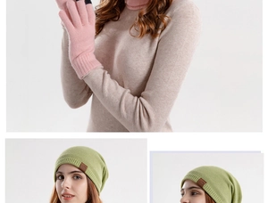 Detail of pink knitted gloves and green beanie with leather tag for winter
