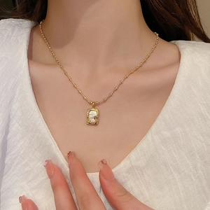 Minimalistische Goldhalskette mit unregelmäßigem Perlmutt-Anhänger am Frauenhals