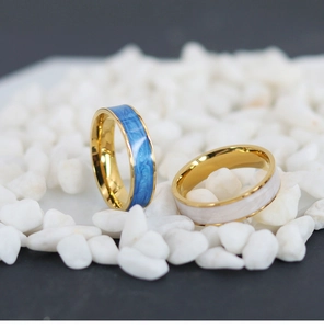 Detail view of 18K gold plated rings with blue marble and white pearl enamel inlays