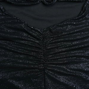 Détail du tissu noir scintillant avec un design plissé sur la poitrine d'une robe