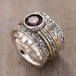 Macro detail of vintage wide ring featuring purple gemstone and intricate floral engravings