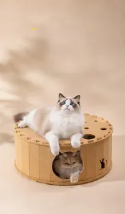 Close-up of khaki felt cat tunnel bed featuring cat-shaped cutouts in cozy home setting