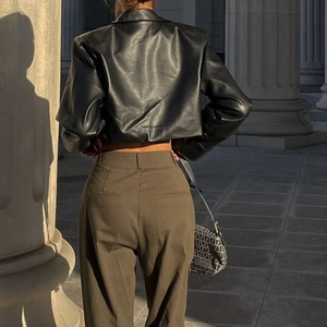 Vue arrière d'un blouson court en cuir noir et pantalon marron style urbain chic