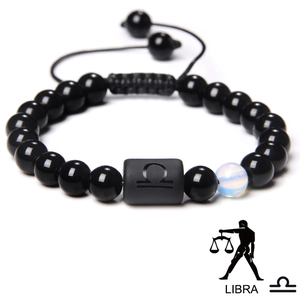 Detail of adjustable woven Libra bracelet with black beads and engraved zodiac symbol