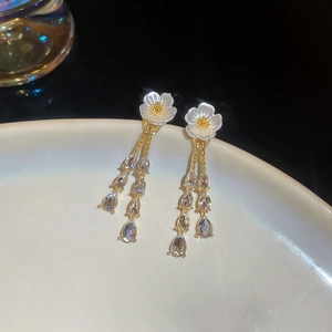 Detail of floral tassel earrings with mother of pearl petals and crystal teardrops