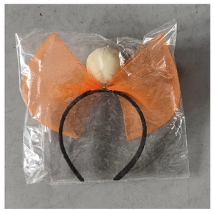 Detailed view of an orange mesh bow headband with white sphere ornament in packaging