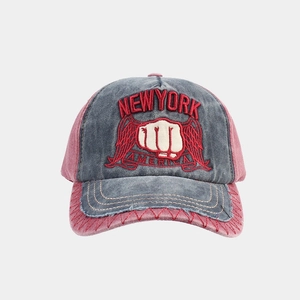 Close-up of vintage washed cotton baseball cap with embroidered fist and wing design