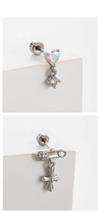 Macro detail of silver steel stud earrings featuring heart opal and gothic cross pendant