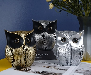 Detailed view of three resin owl figurines with dotted textures in home decor setting