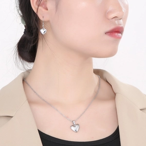Parure collier et boucles d'oreilles cœur minimaliste en acier argenté sur mannequin
