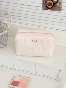 Detailed macro view of the 3D rose flower ornament on a knitted makeup organizer bag