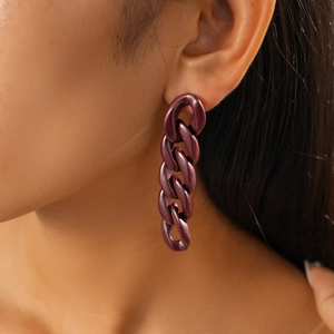 Close-up of purple acrylic chain link earrings with silver needles shown on a model