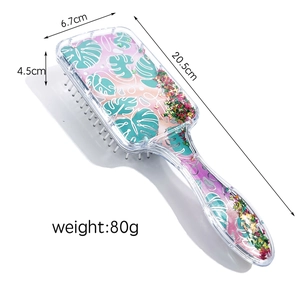 Detail view showing dimensions of transparent hair brush with glitter and leaf patterns