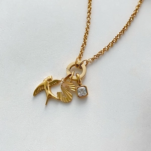 Gold-plated stainless steel necklace featuring a swallow, letter S, and zircon charm.