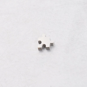 Vue macro d'un pendentif puzzle en acier inoxydable poli pour la création de bijoux