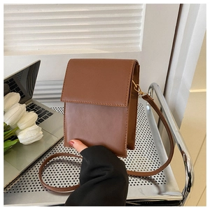 Close-up of a brown PU leather crossbody phone bag shown in a professional office setting