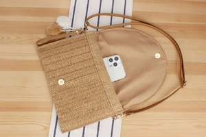 Detail view of woven paper rope envelope bag interior holding a smartphone