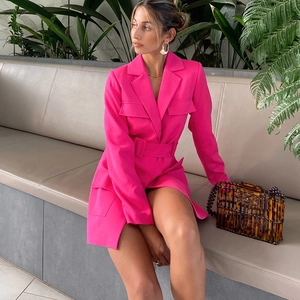 Robe blazer rétro rose à manches longues avec ceinture portée par un mannequin en plein air
