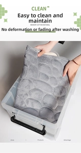 Detail of grey memory foam bath mat with pebble texture showing softness and washability