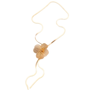 Detailed view of a gold floral pendant on a sleek flat snake chain necklace