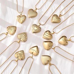 Gold stainless steel heart locket necklace collection on elegant white fabric