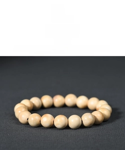 Macro detail of polished natural wood beads showing smooth grain and creamy white texture