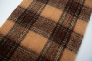Close-up of brown and dark tan plaid scarf fabric showing soft fuzzy wool texture