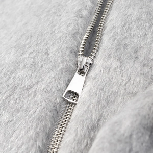 Close-up of durable silver metal zipper on premium soft grey faux fur autumn jacket
