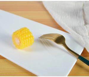 Macro shot of realistic corn model with detailed kernels on white ceramic plate