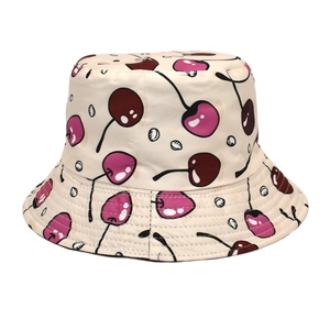 Reversible bucket hat with cherry print for sun protection in a minimalist cream color