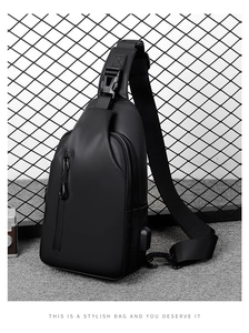 Detail der schwarzen Brusttasche mit integriertem USB-Ladeanschluss und Reißverschluss