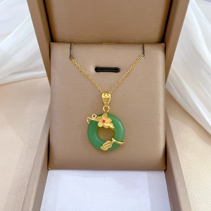 Elegant gold titanium necklace with a green jade flower pendant on beige silk