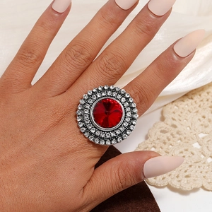 Detailed close-up of a vintage adjustable ring featuring a large red crystal and silver band
