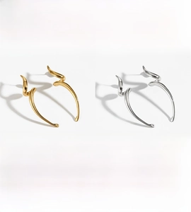 Macro detail of PVD plated stainless steel spiral earrings in gold and silver finish