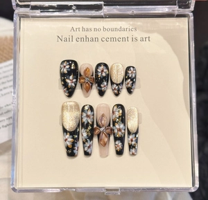 Detailed view of handmade press-on nails with 3D gold flowers and hand-painted art