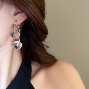 Close-up of minimalist silver cherry earrings with transparent double bubble spheres