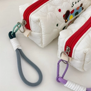 Detail of heart quilting and colorful embroidery on a white large pencil pouch