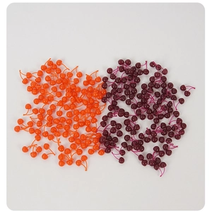 Vista macro de cerezas miniatura en naranja y rojo oscuro para manualidades creativas DIY