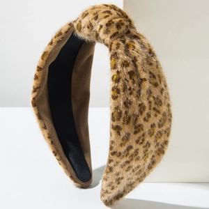 Détail du serre-tête en fausse fourrure léopard avec design noué et texture douce