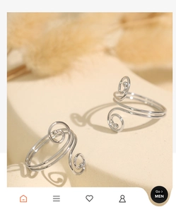 Macro detail of silver spiral open rings with minimalist double swirl design on stone