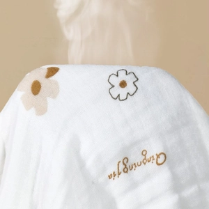 Soft 6-layer cotton gauze baby bath towel with minimalist floral print in off-white tones