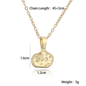 Detailed view of gold irregular pendant necklace with tree engraving and clear crystals