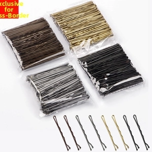 Detail view of wavy metal snap hair clips in black, gold, silver and brown finishes