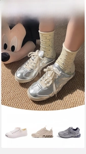 Detailed view of silver metallic sneakers paired with polka dot cotton crew socks