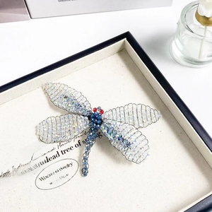 Detailed view of a handmade dragonfly brooch with colorful crystal beads and wire frame